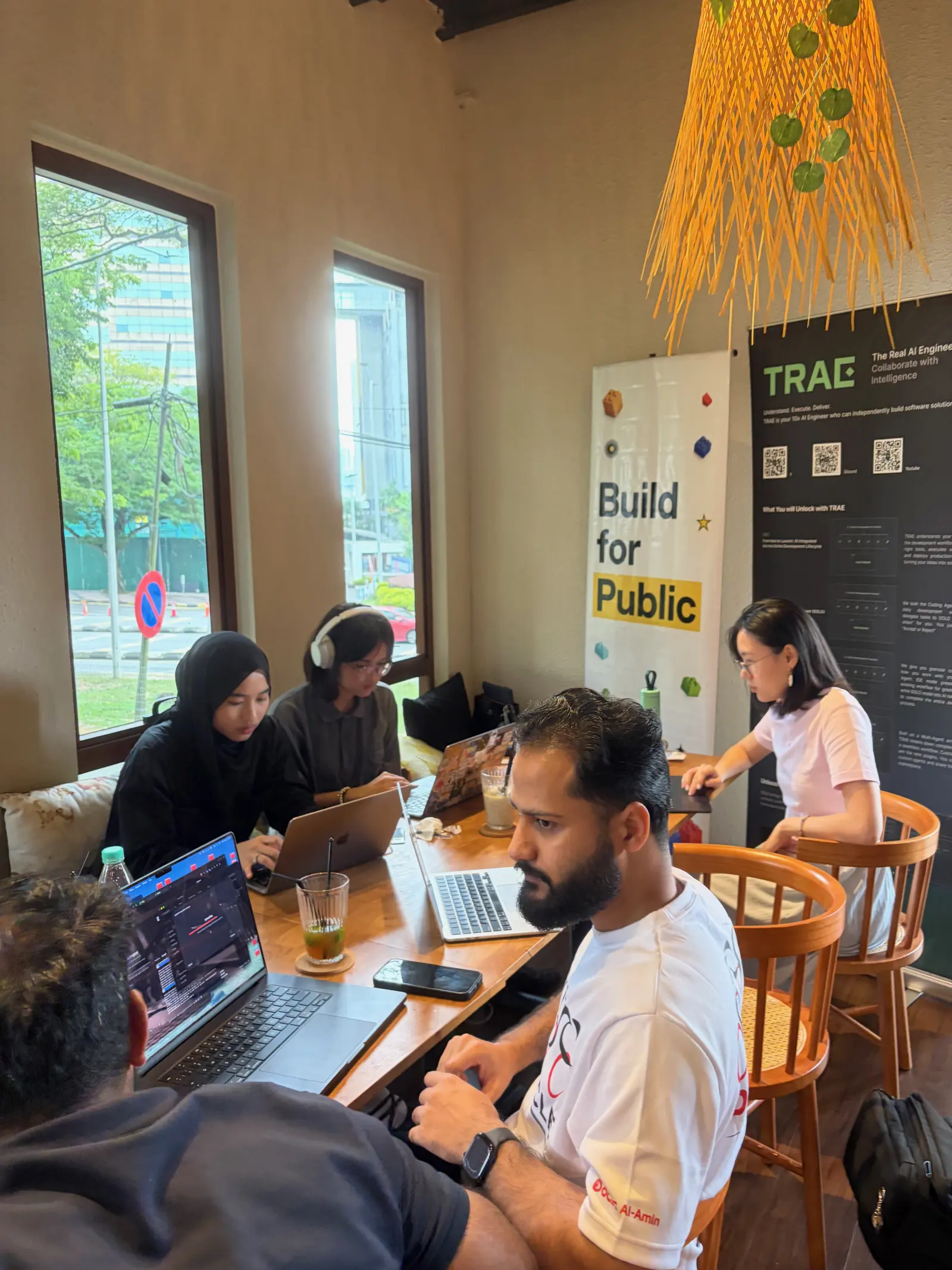Two builders heads-down on an NGO site, laptops open